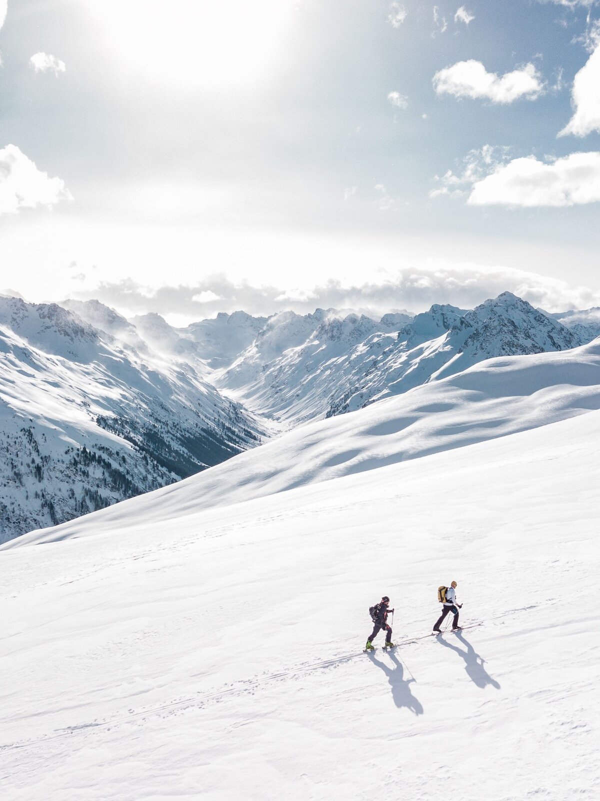 Trekkers on a sunlit snow ridge
